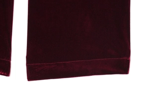 Detail shot of the velvet blazer sleeve with intricate stitching in deep red