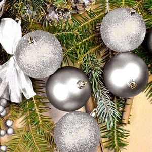 Macro detail of silver and grey Christmas balls with glitter and matte finish on pine needles