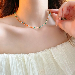 Close-up of colorful handmade seed bead choker necklace on female neck in natural light