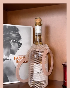 Detailed close-up of pink beaded wine bag and transparent handles on a bottle