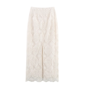 Dettaglio di elegante gonna in pizzo beige con ricami floreali e spacco laterale chic
