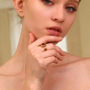 Detail of 18K gold plated double-layer ring with oval red gemstone on female hand