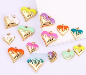 Macro shot of colorful enamel heart pendants with gold-plated edges for DIY jewelry making