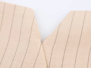 Détail de couture en V et texture à rayures verticales sur tissu tissé kaki