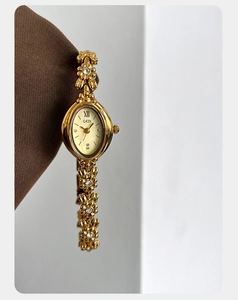 Detailed view of floral bracelet watch links with sparkling crystals and golden finish