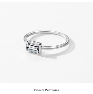 Macro detail of rectangle emerald cut zircon set in silver band with mirror finish