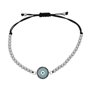 Detail of silver beaded evil eye bracelet with blue stone charm and adjustable black cord