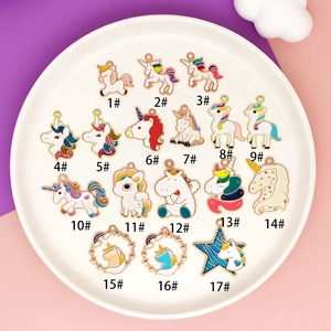 Detailed close-up of 17 colorful DIY enamel unicorn pendants on a white ceramic tray