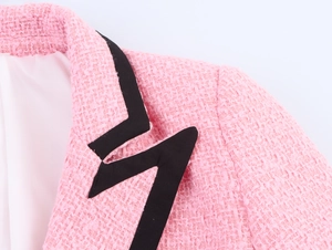 Detaillierte Makroaufnahme vom Ausschnitt der rosa Tweed-Jacke mit schwarzem Kontrastsaum