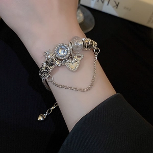 Silver bead bracelet with crystal stones, heart pendant and crown charm on a wrist