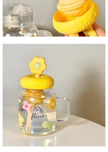 Detail of floral glass cup with yellow silicone lid and matching flower stirrer stick