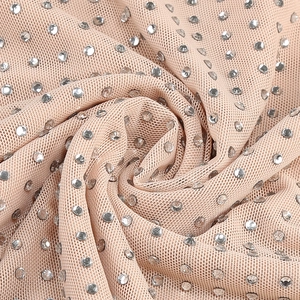 Macro shot of nude mesh fabric featuring dense silver rhinestones and delicate texture