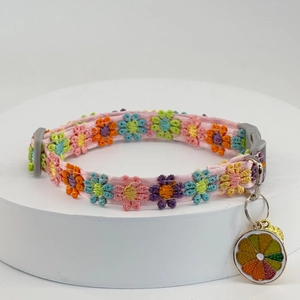 Detailed close-up of a colorful floral lace pet collar with an orange slice metal charm