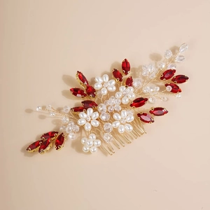 Detail of golden hair comb with red leaf crystals and white pearl flowers for brides