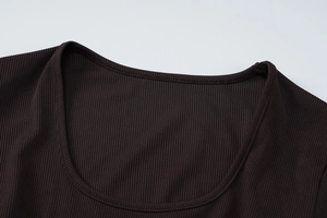 Dettaglio della trama in maglia a coste marrone scuro e cuciture di qualità sullo scollo a U