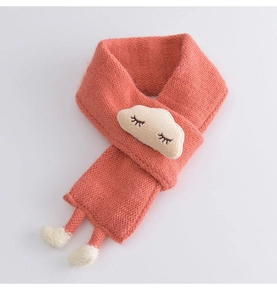 Detail of coral knit baby scarf with white cloud patch and fluffy pom-pom tassels