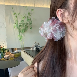 Pinza per capelli a fiore 3D in tessuto con petali di rete rosa indossata su capelli