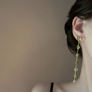 Long tassel earrings with golden chains and translucent green strawberry crystal beads
