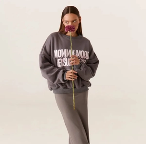 Detailansicht eines dunkelgrauen Sweatshirts mit rosa-weißem Buchstaben-Aufdruck