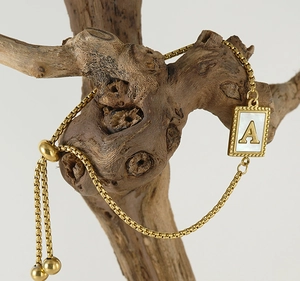 Detail of gold letter A shell charm bracelet with adjustable sliding box chain