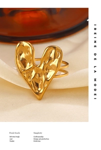 Detail of gold heart-shaped ring with hammered texture on elegant silk background