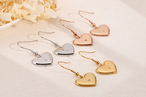 Detailed view of heart-shaped drop earrings in silver, gold, and rose gold with rhinestones