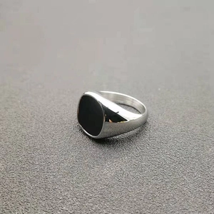 Close-up of polished silver stainless steel signet ring with a black square inlay detail