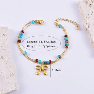 Detail view of gold beaded bracelet with blue charms and bow pendant, length 16.5+3.5cm