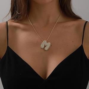 Close-up of model wearing 18K gold plated zircon bubble letter M pendant necklace