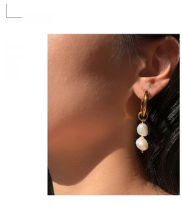Detail of French vintage gold hoops with baroque pearls on model with natural light