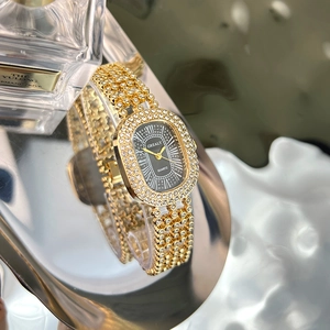 Detail of luxury ladies oval gold watch with crystal encrusted bracelet and black dial