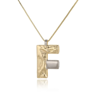Macro detail of gold-plated letter F necklace featuring unique lava texture on white background