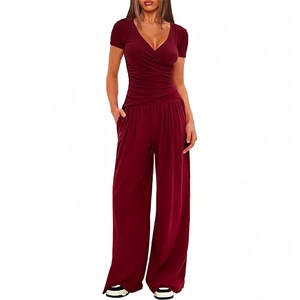 Detailed view of women's burgundy V-neck pleated top and wide-leg trousers set