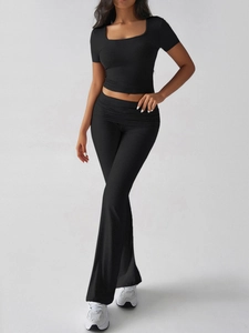 Detail of black Y2K crop top and high-waisted flared pants set on a clean background