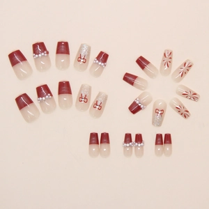 Détails de faux ongles rouges avec perles et motifs de nœuds à paillettes