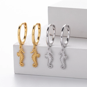 Macro detail of S925 sterling silver seahorse drop earrings in gold and silver finish