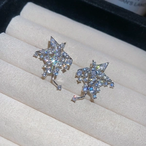 Vue macro de boucles d'oreilles étoiles en argent avec zircons sur un plateau en velours