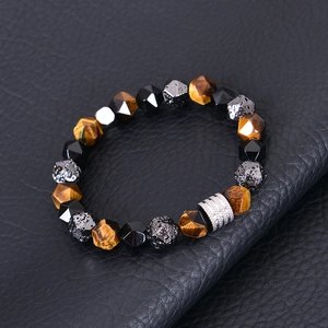 Détail de perles d'œil de tigre et de perles noires facettées sur bracelet tressé