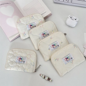 Close-up of quilted cotton pouches with colorful embroidery and SOZ AKKA happy patches