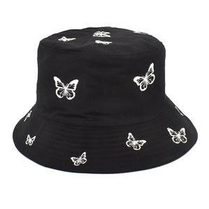 Détail de la broderie papillon blanc sur le tissu en coton noir d'un chapeau bob