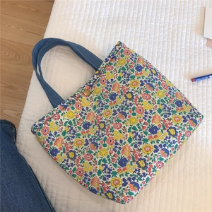 Close-up of a floral cotton tote bag with a vintage bronze snap button closure