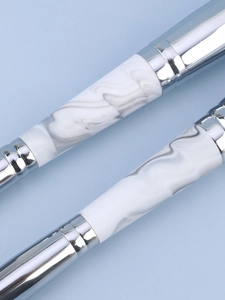 Detail of silver metal and marble pattern handle on a dual-ended makeup brush set