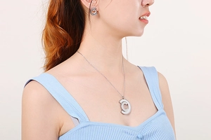 Detail of silver stainless steel necklace and earrings with hollow C-letter pattern