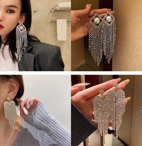 Close-up of elegant U-shaped pearl tassel earrings with shimmering rhinestone accents