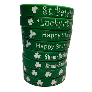 Vertical stack of green St. Patrick's Day silicone wristbands with festive white clover patterns
