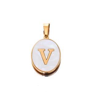 Detail of oval gold-plated pendant with white shell inlay featuring a metal letter V