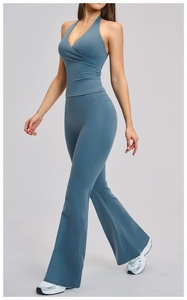 Detail of high-waist flared yoga pants and halter neck sports top in dusty blue fabric
