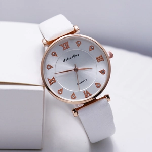 Détail macro d'une montre à quartz rose dorée avec chiffres romains et cristaux