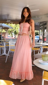 Detail of light pink summer set showing textured fabric and bow strap top in sunlight