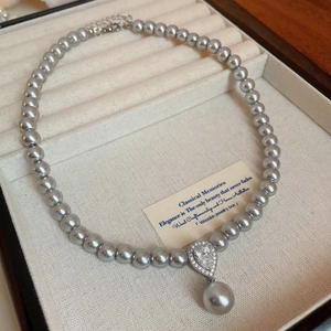 Detail of grey pearl necklace with a sparkling teardrop zircon pendant in a jewelry box